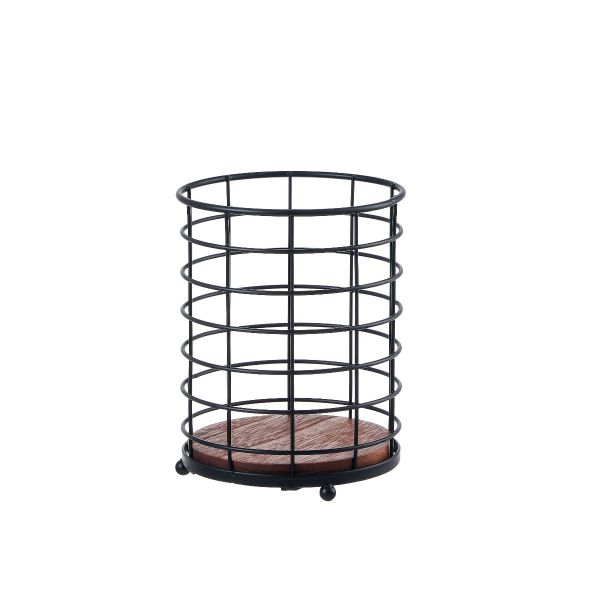 Black round cutlery holder basket with dark brown wooden base on a kitchen countertop