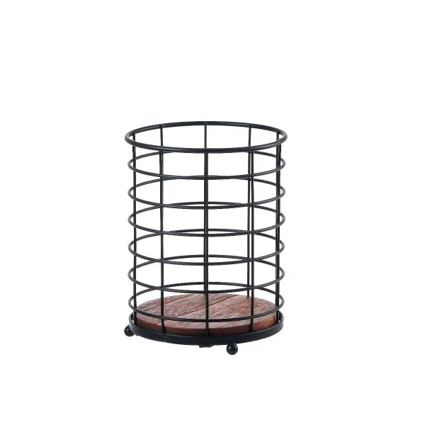 Black round cutlery holder basket with dark brown wooden base on a kitchen countertop